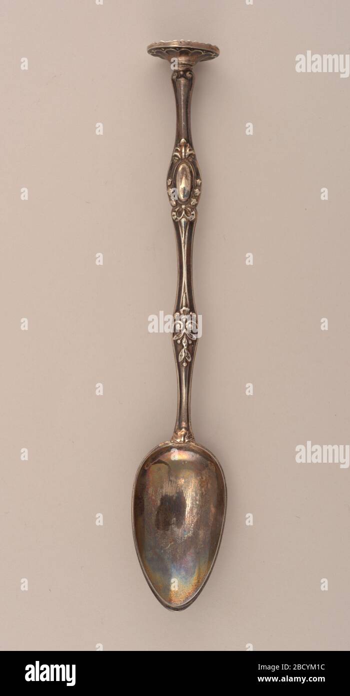 Spoon. Research in ProgressOval bowl, the shaped stem embossed with berried sprig at mid-stem and ribbon-tied, bell flower surrounded oval cartouche above, with oval crusher, the underside chased with gadroons. Spoon Stock Photo