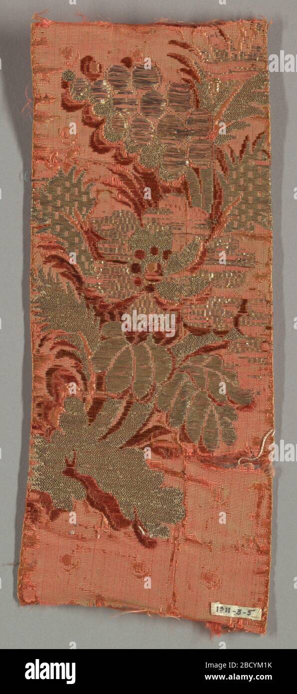 Fragment. Research in ProgressRed-orange ground with an incomplete spray of a flower and decorative foliage with brocading in two shades of red and flat metallic strips, metallic thread and metallic frisé thread. Fragment Stock Photo