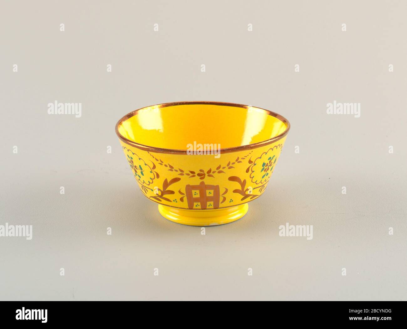 Bowl. Research in ProgressFooted bowl with copper luster decoration with foliage and square motifs on a yellow background; rim is copper luster. Bowl Stock Photo