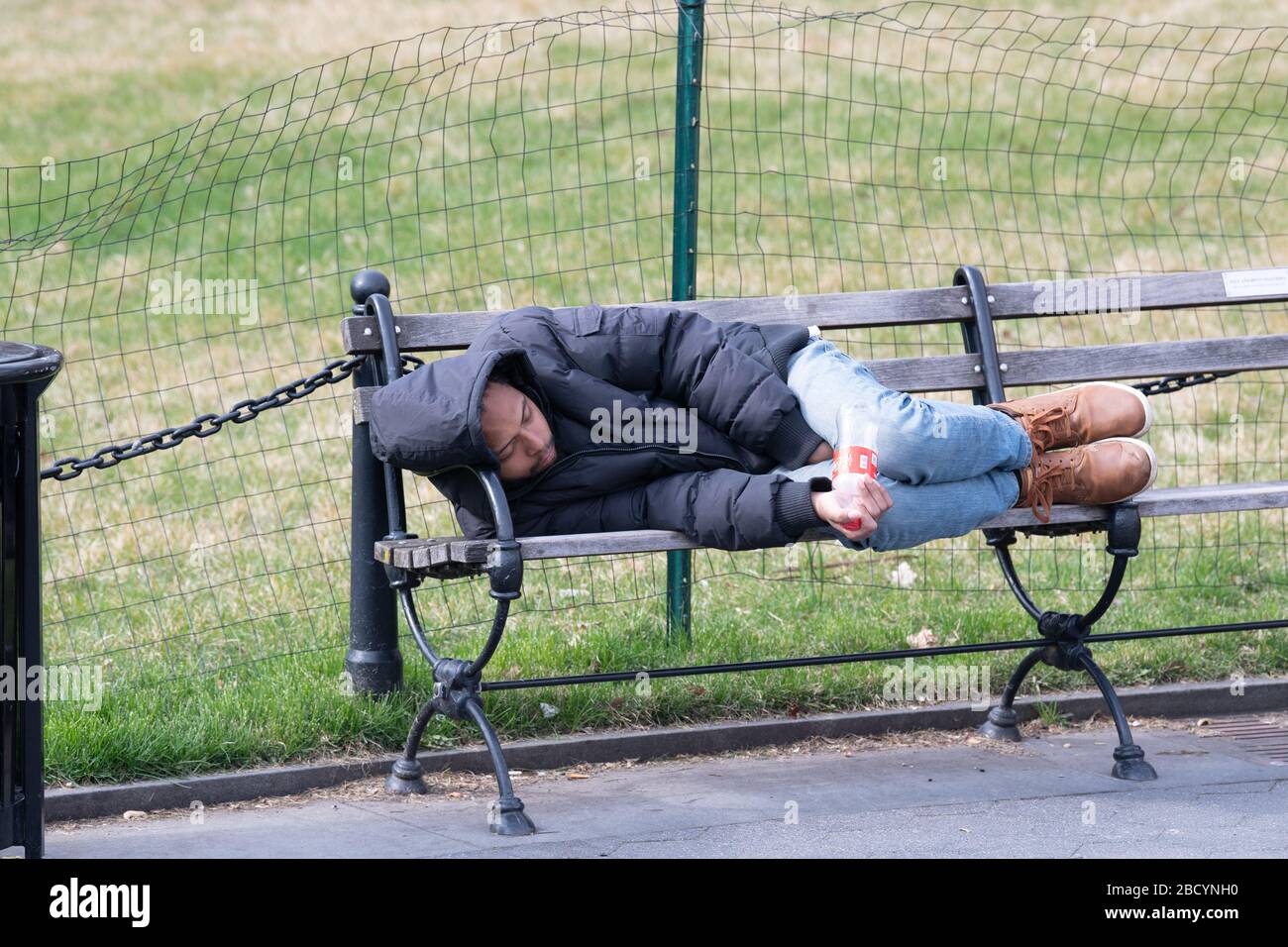 NEW YORK, NEW YORK - APRIL 05: A man sleeps on a bench in Washington ...