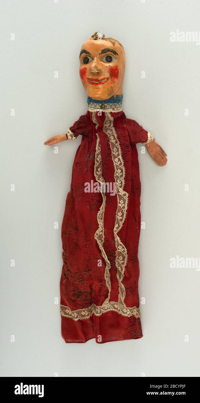 Puppet. Research in ProgressWide-eyed face with red cheeks. Figure dressed  in red and white lace, blue fringe at the neck. Remains of crepe hair.  Puppet Stock Photo - Alamy