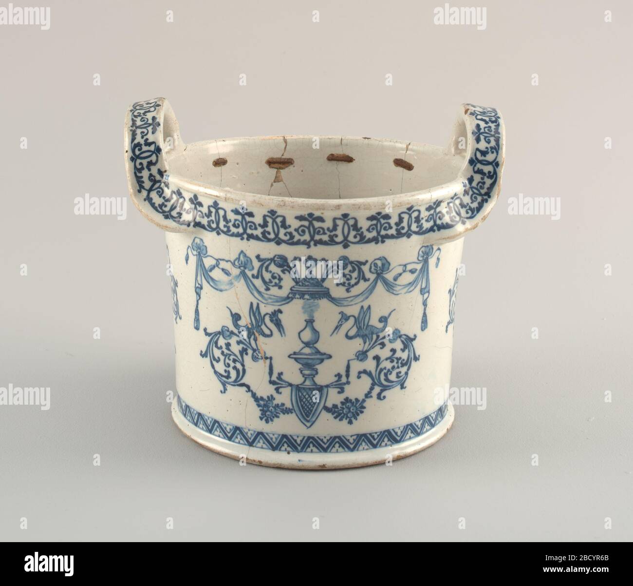 Cooling pail. Research in ProgressCircular, with slightly flaring sides and two large strap handles. Chevron decoration about base, foliate band about top. Sphinxes and harpies on one face; foliate decoration on sides below handles; chimeric beasts on other face. Cooling pail Stock Photo