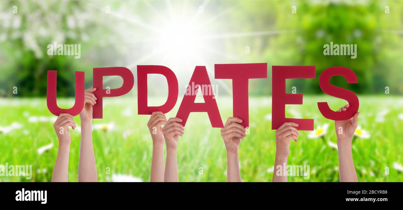 People Hands Holding Word Updates, Grass Meadow Stock Photo