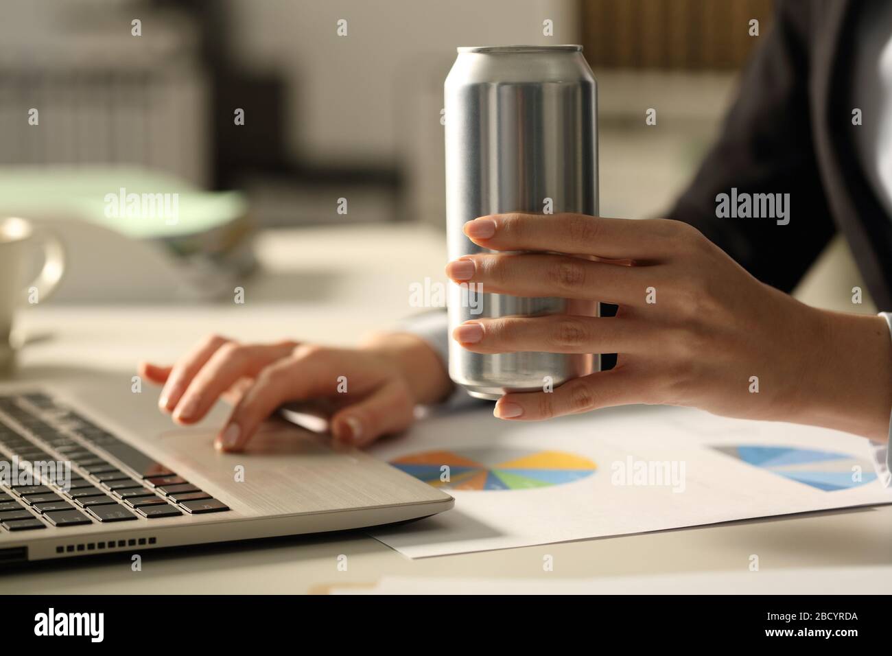 Close up of business woman hands holding soda can at night in the office Stock Photo