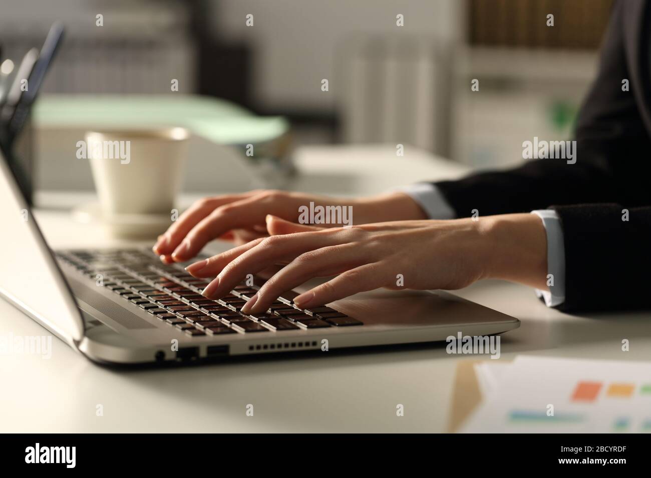 Close up of executive woman hands typing on laptop in the office at night Stock Photo