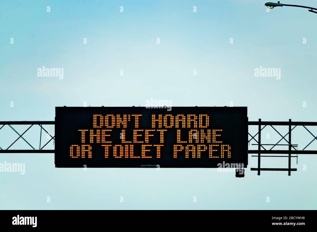 An electronic sign on I-10 West encourages motorists not to “hoard the left lane or toilet paper” during the COVID-19 pandemic in Mobile, Alabama. Stock Photo
