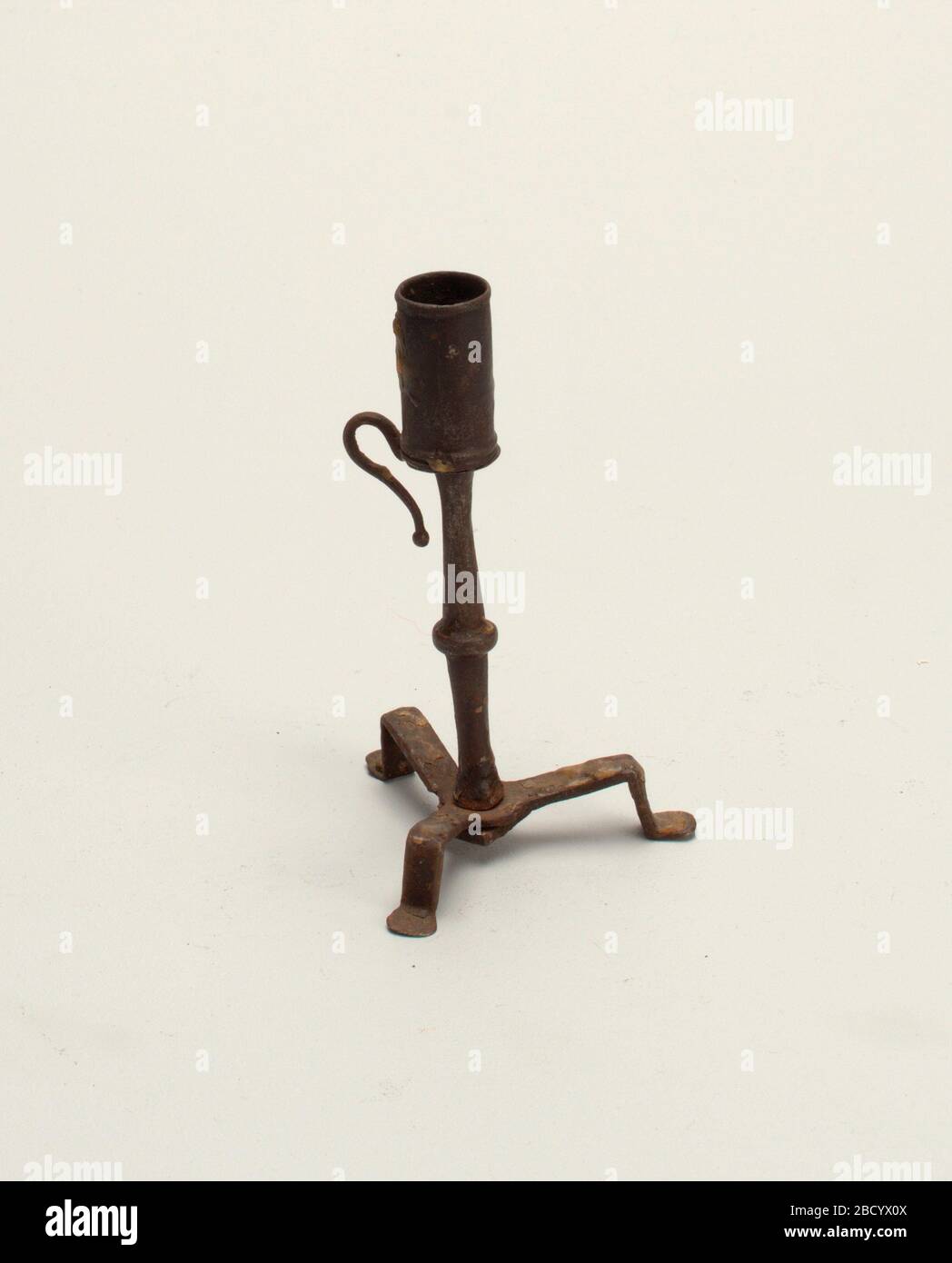 Candle holder. Research in ProgressA tripod base with simple, flat feet. Small knob halfway up the stem. Handle with ball finial. Candle holder Stock Photo