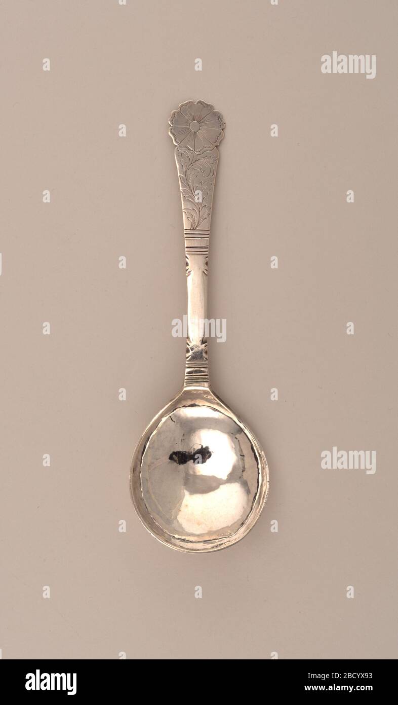 Spoon. Research in ProgressA spoon with rounded fig-form bowl, the flat stem flaring to flower-form terminal. The obverse of the stem engraved with scrolling foliage topped by engraved flower head. The reverse of the terminal engraved with flower heads and foliage. Spoon Stock Photo