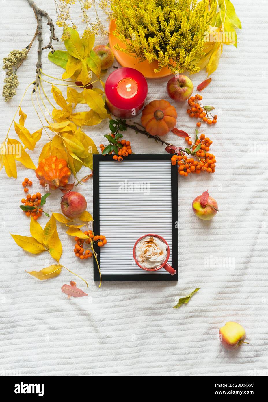 Autumn lifestyle flat lay with empty letter board , hot chocolate, burning candle, pumpkins and yellow fall leaves branches. Top view. Cozy home. Autu Stock Photo