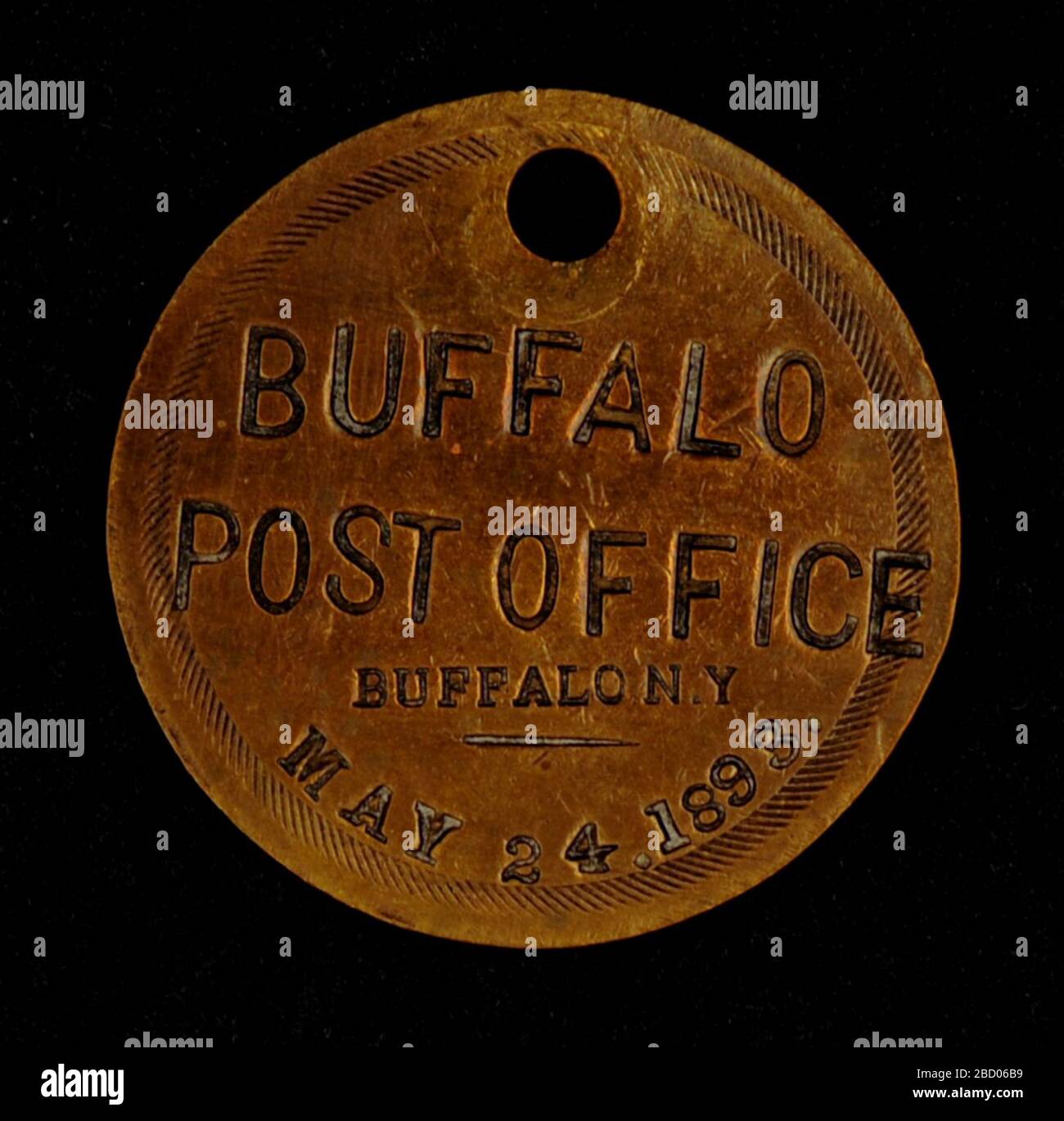 Buffalo New York Owney tag. Postal workers at the Buffalo, New York, post office presented this round brass tag to Owney on May 24, 1893. It is one of the earliest tags in Owney’s collection. At first, Owney did not travel far from home, including this May trip. Buffalo New York Owney tag Stock Photo