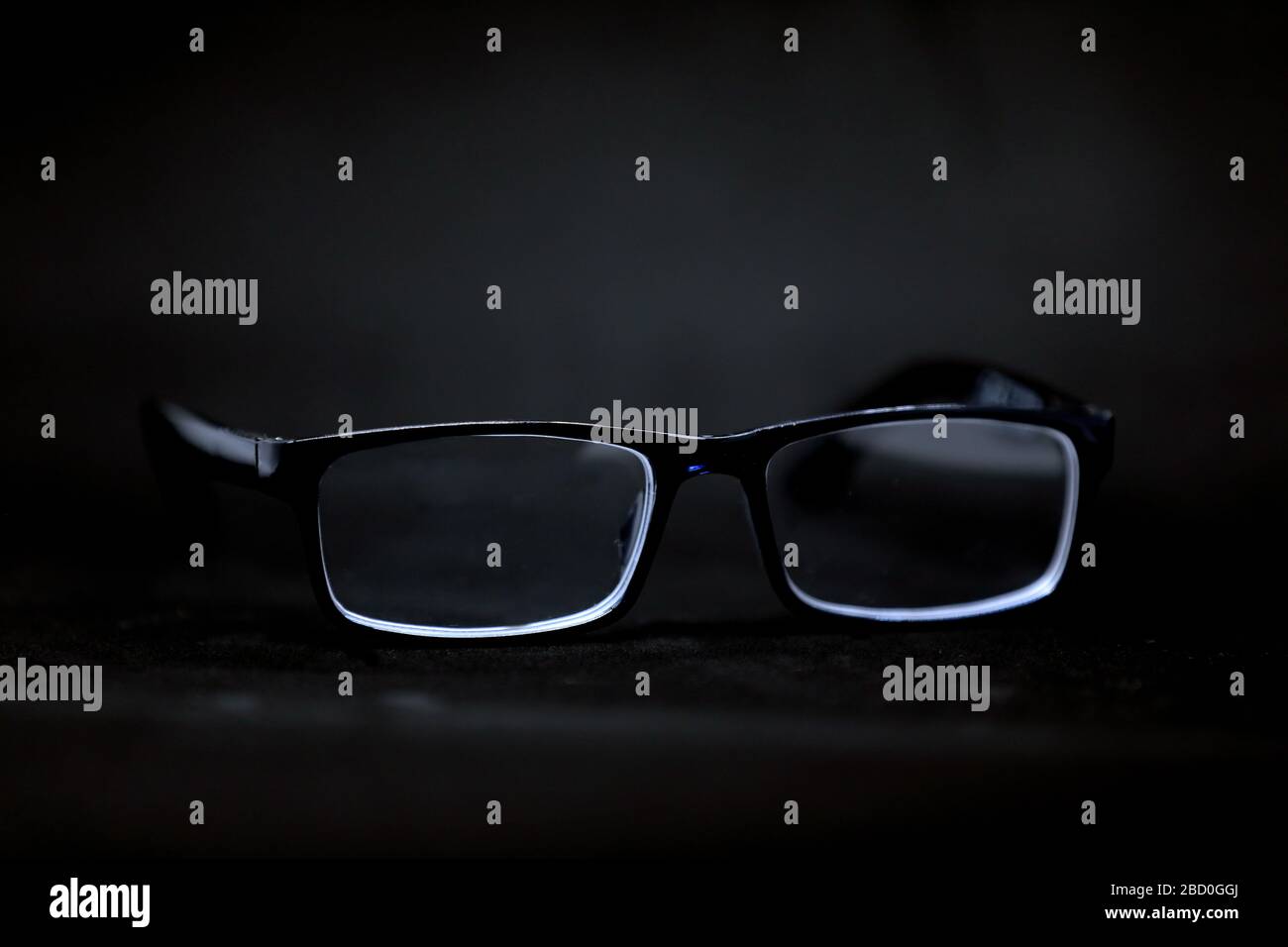 Black glasses isolated on a black background. Big brother is watching. Abstract. Stock Photo