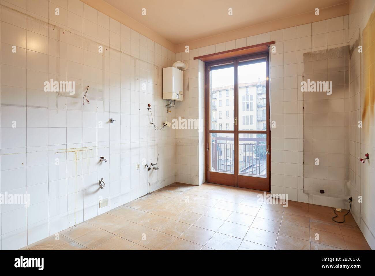 Old, empty kitchen interiror with dirty tiles and boiler Stock Photo