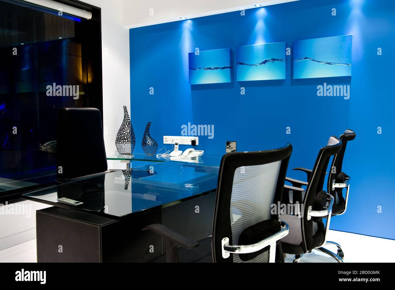 Modern manager office interior with a Blue walls, a stylish table, chairs  and Painting Stock Photo - Alamy