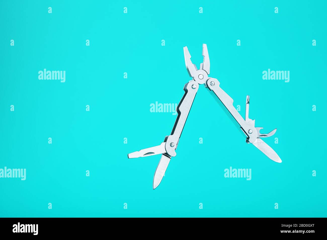 The multitool multi-function tool hovers on a blue background. The concept of an expanded multi-tool with free space. Stock Photo
