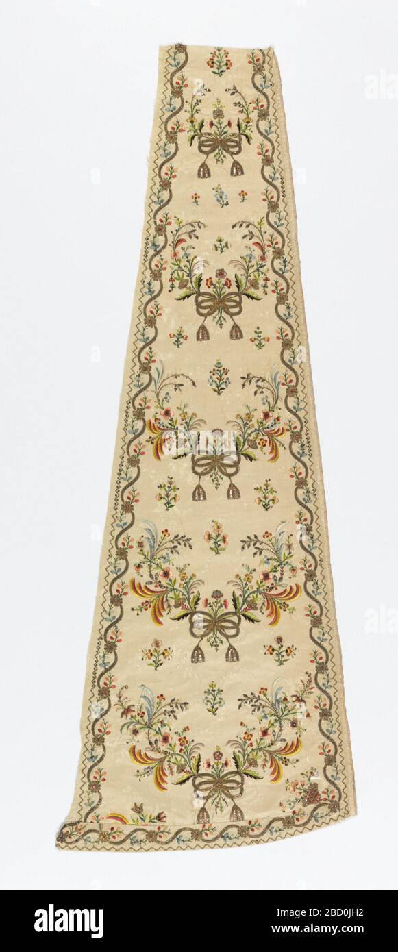 Panel. Research in ProgressLong, narrow shaped panel, probably from a skirt, that is narrower at the top and curved at the bottom. Cream-white twill weave with brocading in a small floral design. Embroidered in multicolored silks, metallic threads and paillettes. Panel Stock Photo