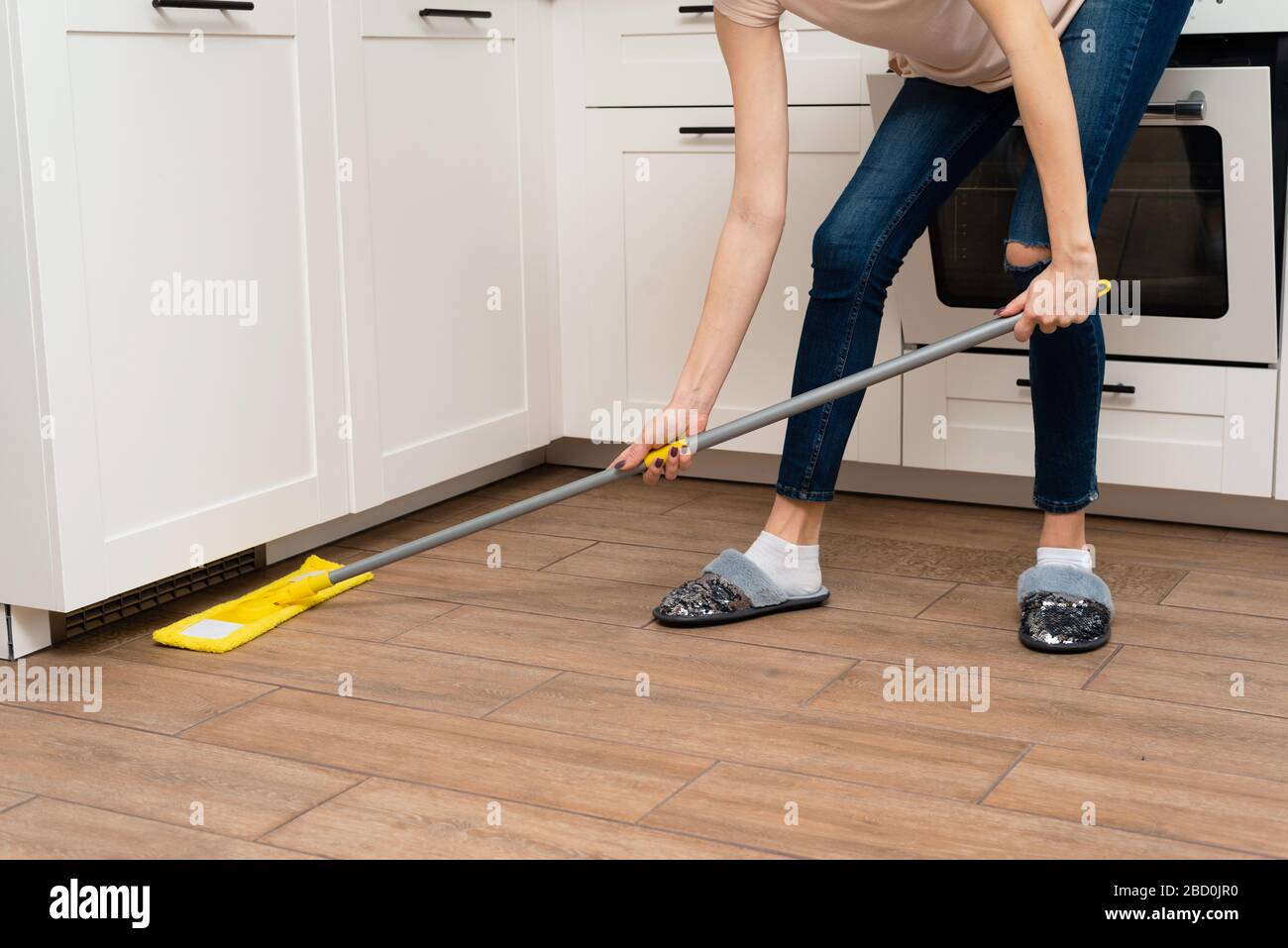 A Young Woman Is Washing Wooden Floors From A Laminate In A Bright