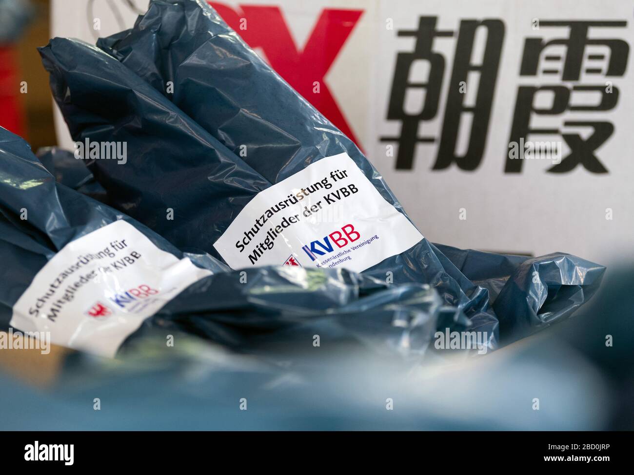 Potsdam, Germany. 06th Apr, 2020. Protective equipment packed in blue plastic bags is lying in a warehouse next to a box with Chinese characters. The Kassenärztliche Vereinigung Brandenburg (KVBB) purchased protective items from the contract physicians for the protection of medical personnel, which were then delivered to the practices by the German Red Cross. Credit: Soeren Stache/Zentralbild/ZB/dpa/Alamy Live News Stock Photo