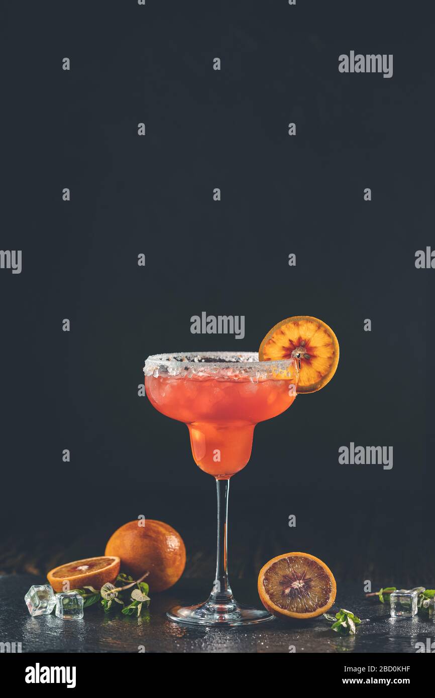 Red orange margarita cocktail with tequila, triple sec, orange juice, crushed ice and some salt
