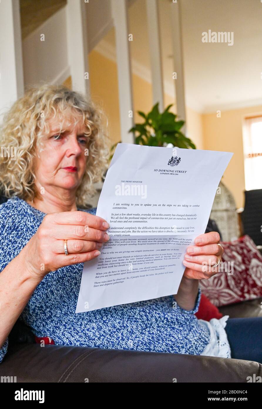 Brighton UK 6th April 2020 - A Brighton resident reads the governments coronavirus update letter sent to every household by Prime Minister Boris Johnson during the Coronavirus COVID-19 pandemic crisis  . Credit: Simon Dack / Alamy Live News Stock Photo