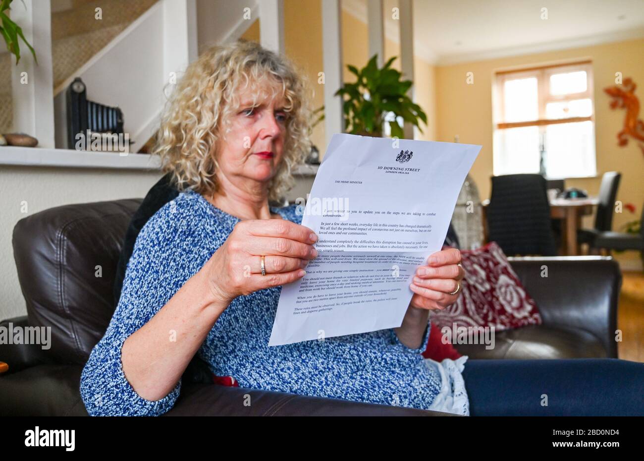 Brighton UK 6th April 2020 - A Brighton resident reads the governments coronavirus update letter sent to every household by Prime Minister Boris Johnson during the Coronavirus COVID-19 pandemic crisis  . Credit: Simon Dack / Alamy Live News Stock Photo
