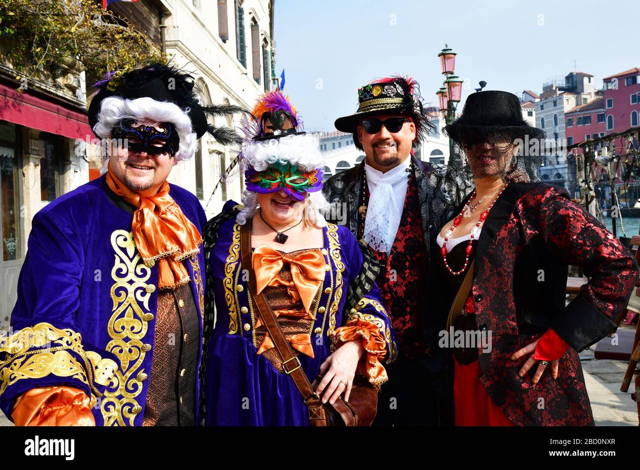 Venice, Italy-February 2020; close up a two man and two woman in traditional masquerade ball costumes for coming carnival in Venice Stock Photo