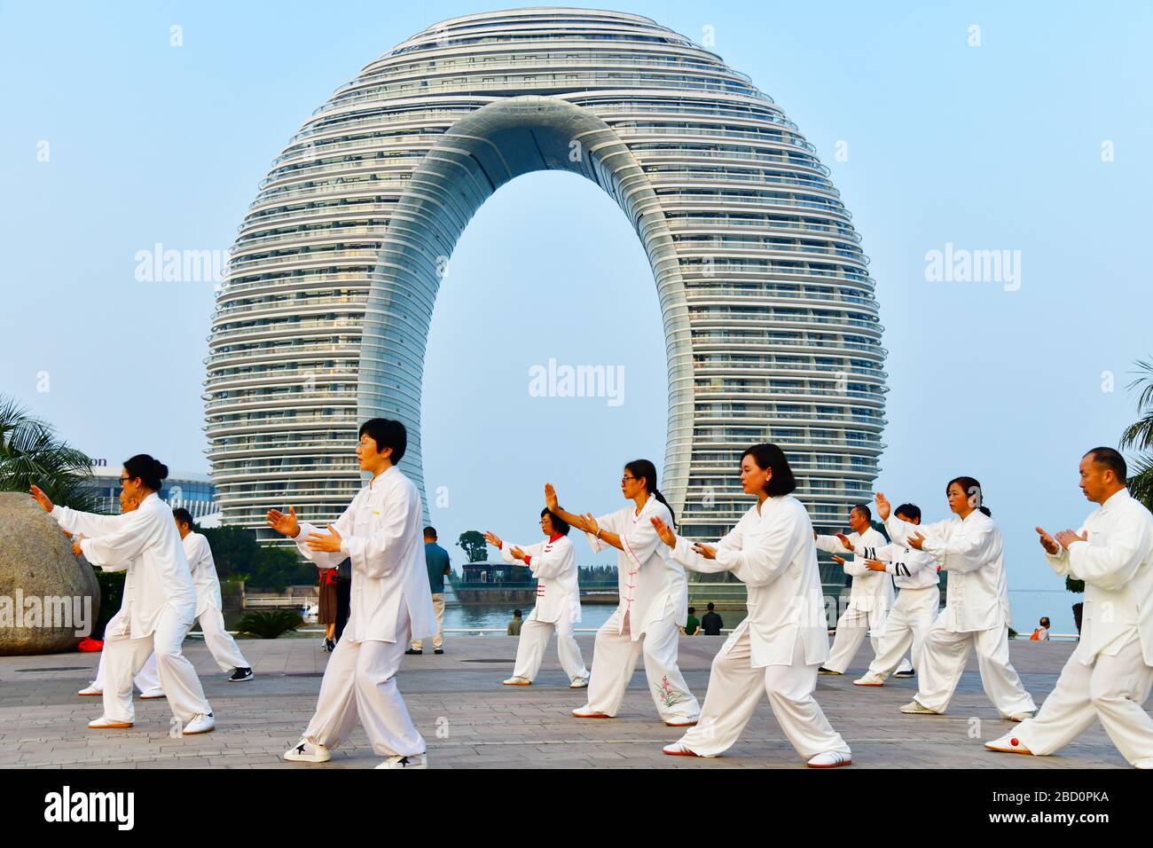 Huzhou, China, October 2019; Large group of people practicing Tai Chi, Yang style in early evening on the shore of Tai Lake Stock Photo