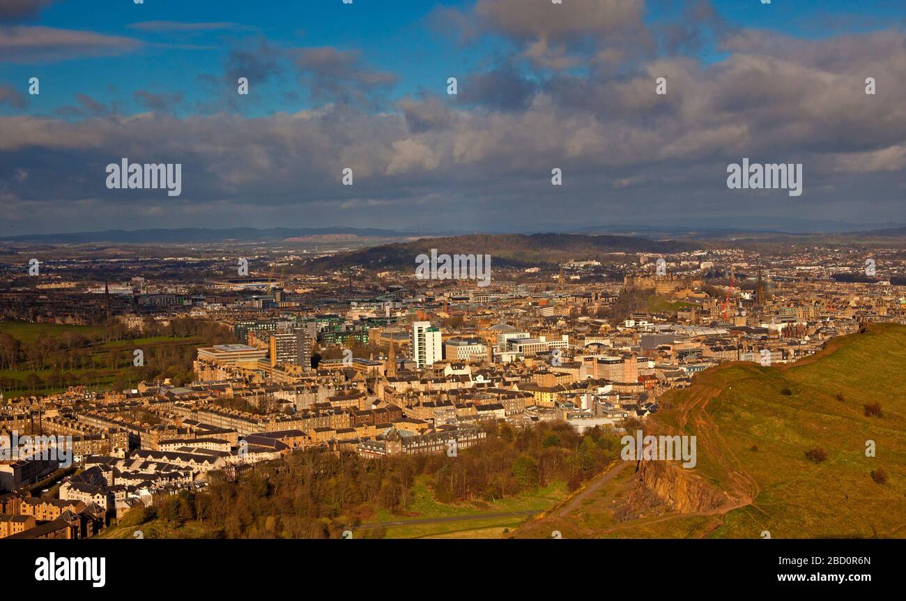 Edinburgh, Scotland, UK. 6th April 2020. As Edinburgh residents prepare to face the third week of the Covid-19 Coronavirus lockdown the morning sun breaks through the previously cloudy sky to give brighter views from Arthur's Seat towards the west over the Salisbury Crags and to the east over Dunsapie Loch towards East  Lothian.Temperature a mild 10 degrees centigrade. Unusual not to have an aeroplane in the distance approaching Edinburgh Airport, as most if not all planes are grounded due to the Pandemic. Credit: Arch White/Alamy Live News. Stock Photo