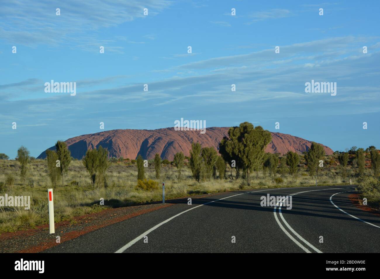 Uluru, Australia-July 2019; panoramic view seen from the curve in the road on large sandstone rock formation in the southern part of the Northern Terr Stock Photo