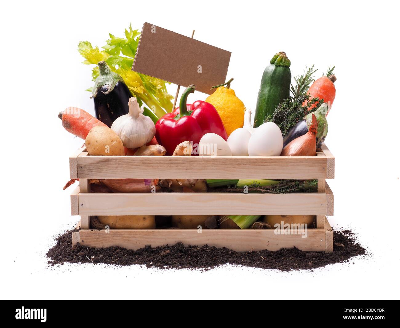 Organic vegetables in wooden rustic box and topsoil with cardboard square tag. Price tag, gift tag, sale tag,  label isolated on white background Stock Photo