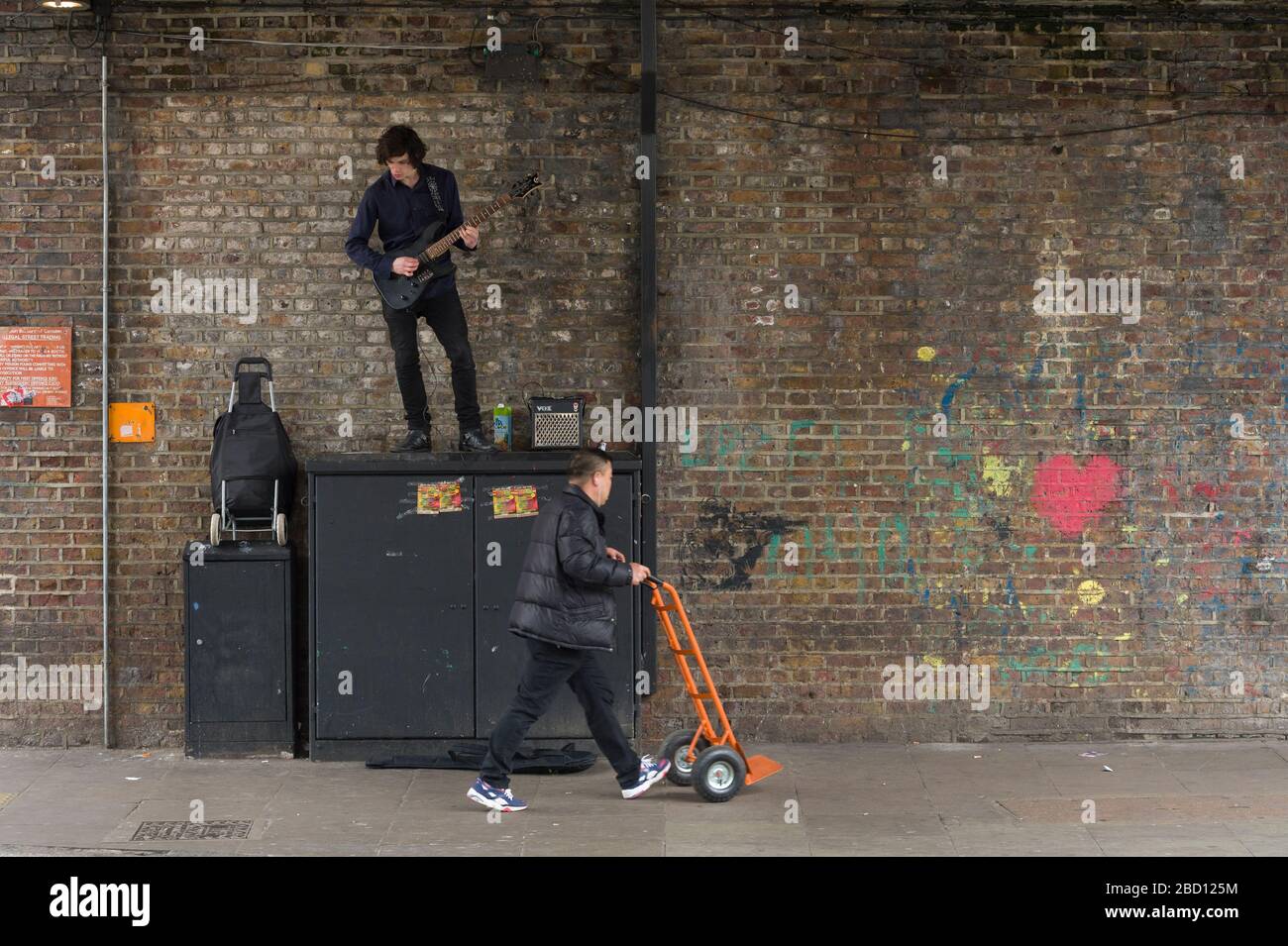 Busker playing a guitar, Chalk Farm Road, Camden Town, London, UK Stock Photo