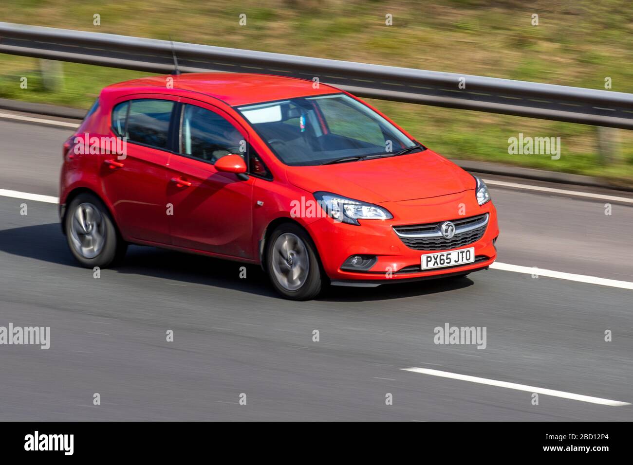 2015 red Vauxhall Corsa Excite AC;  mobile occupational health; Vehicular traffic moving vehicles, driving vehicle on UK roads, motors, motoring on the M6 motorway highway Stock Photo