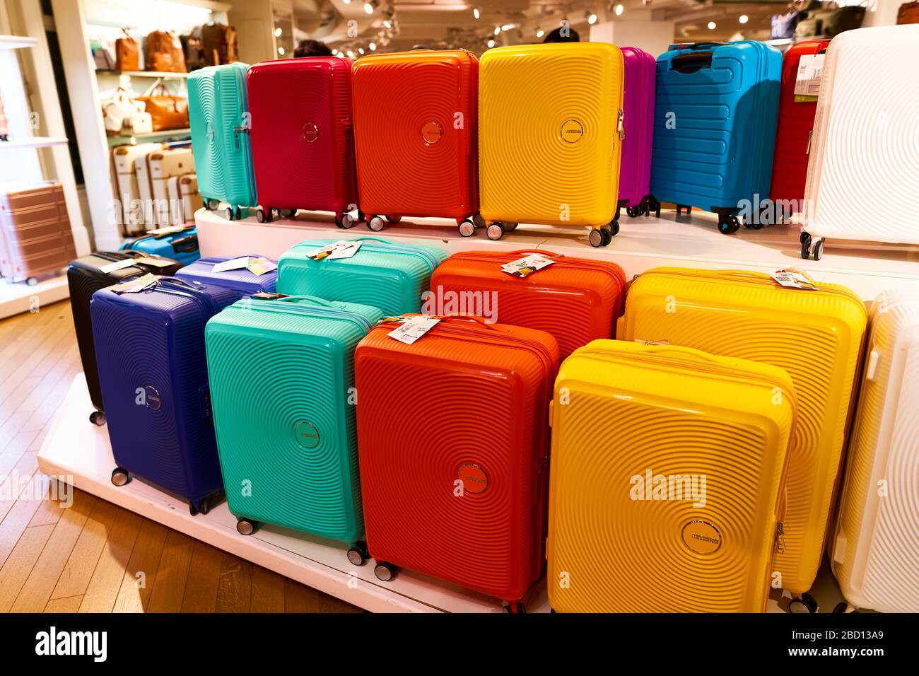 Punchy colored American Tourister Soundbox spinner suitcases in the upmarket department store Galeries Lafayette. Desire or impossibility to travel Stock Photo
