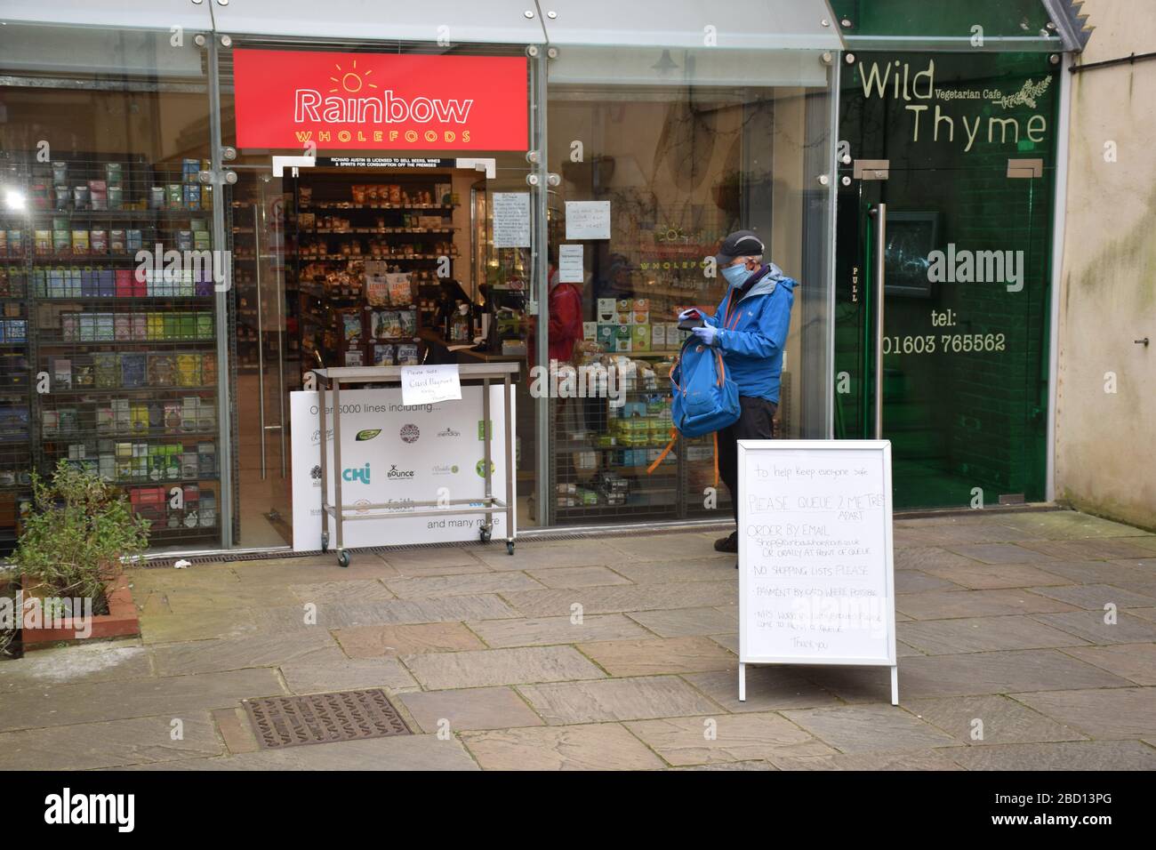 Queueing poster outside local wholefood shop open during Coronavirus