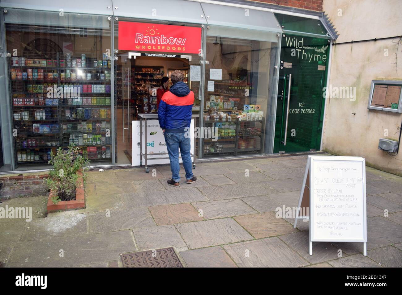 Queueing poster outside local wholefood shop open during Coronavirus
