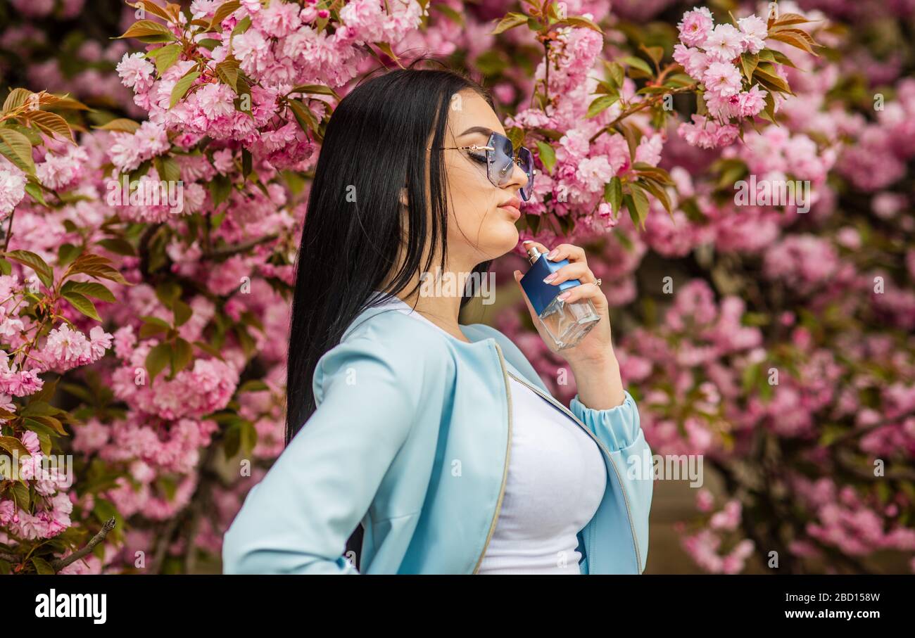 Cherry blossom aroma. Female perfume. Spring perfume. Fancy style. Aromatic  compounds. Natural fragrant essential oils. Eau de Toilette. Luxury  fragrance. Fashionable woman hold perfume bottle Stock Photo - Alamy
