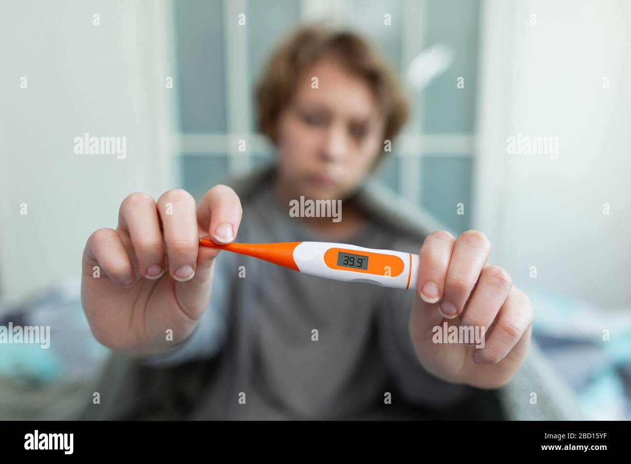 Sick girl with a thermometer Sneezing into tissue. Flu. A woman caught a cold Stock Photo