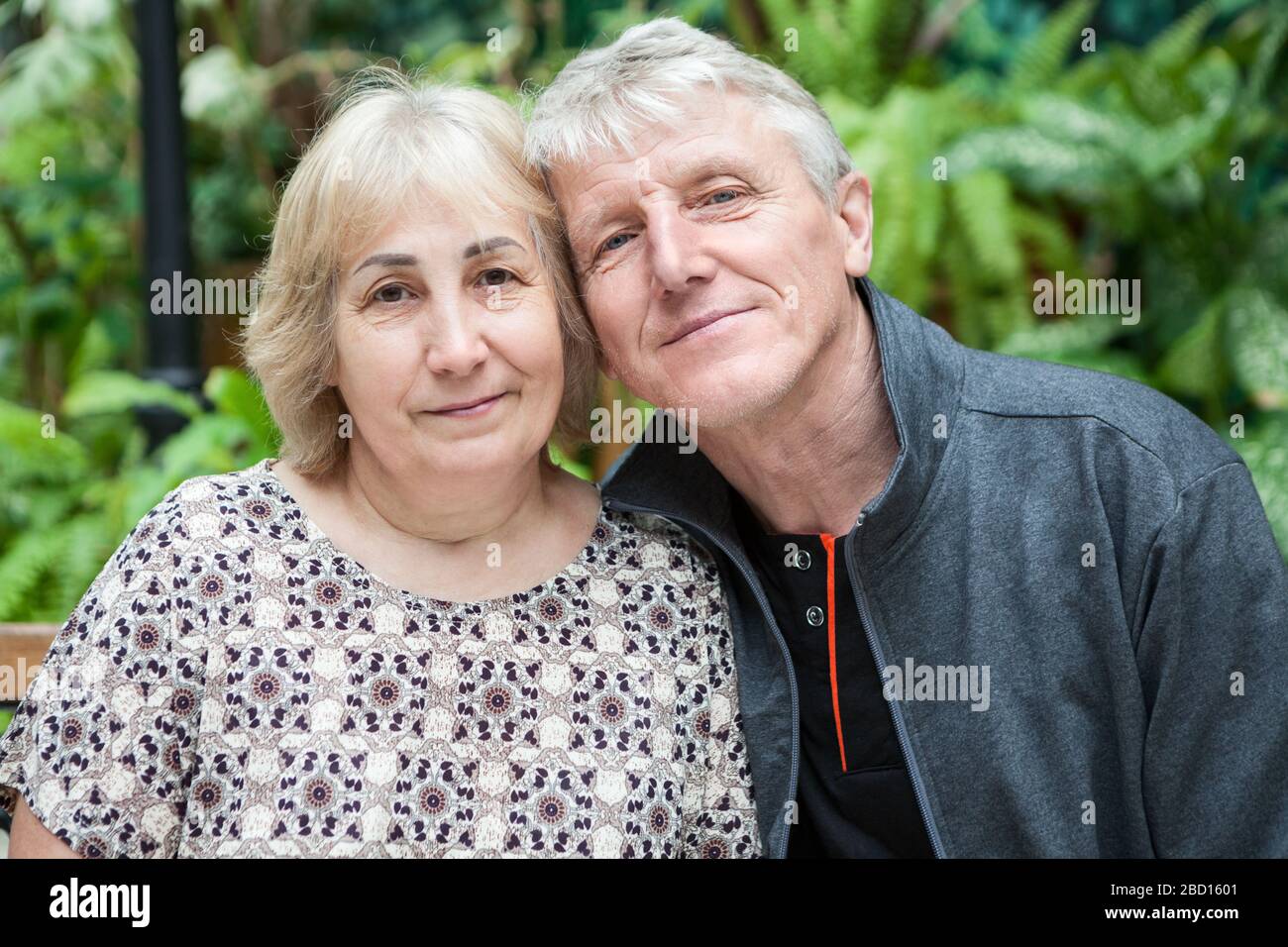 Happy and smiling Caucasian senior couple portrait, sitting cheek to ...