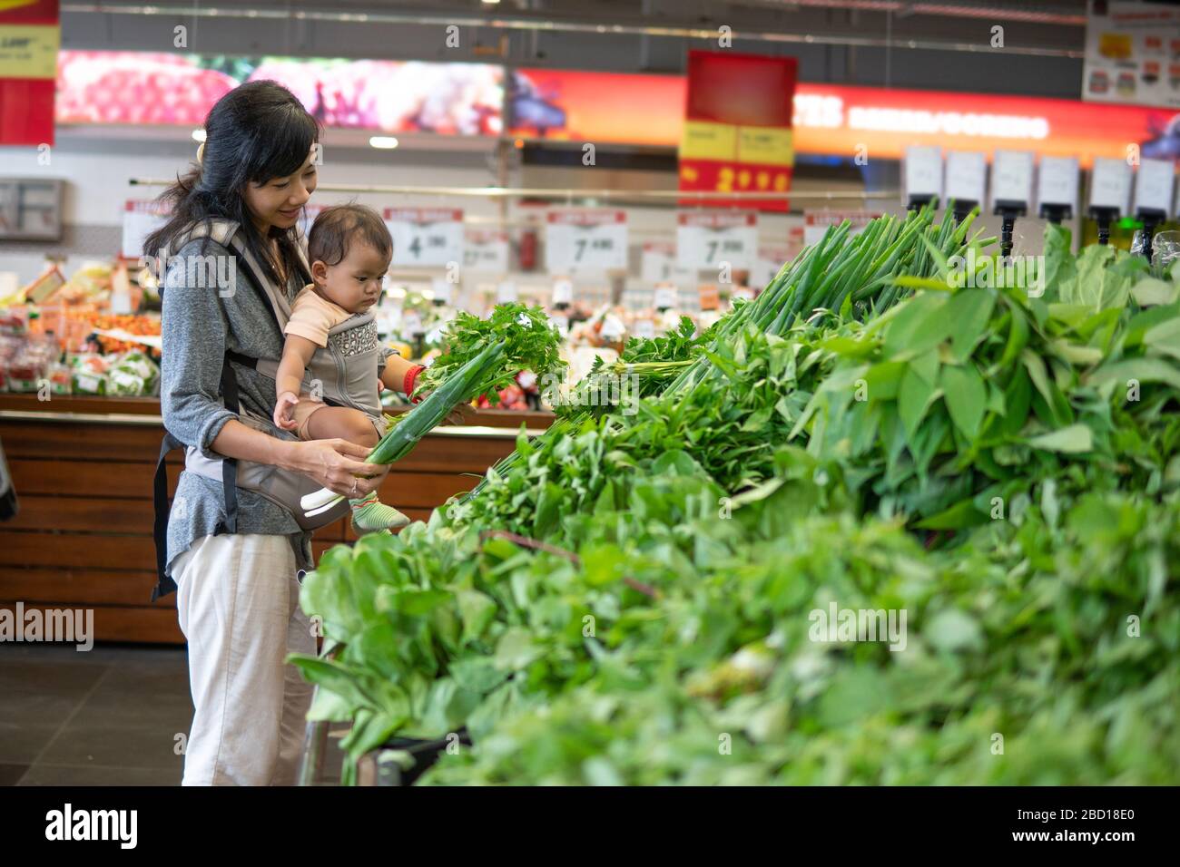 asian Mother and baby shopping in the supermarket. grocery store