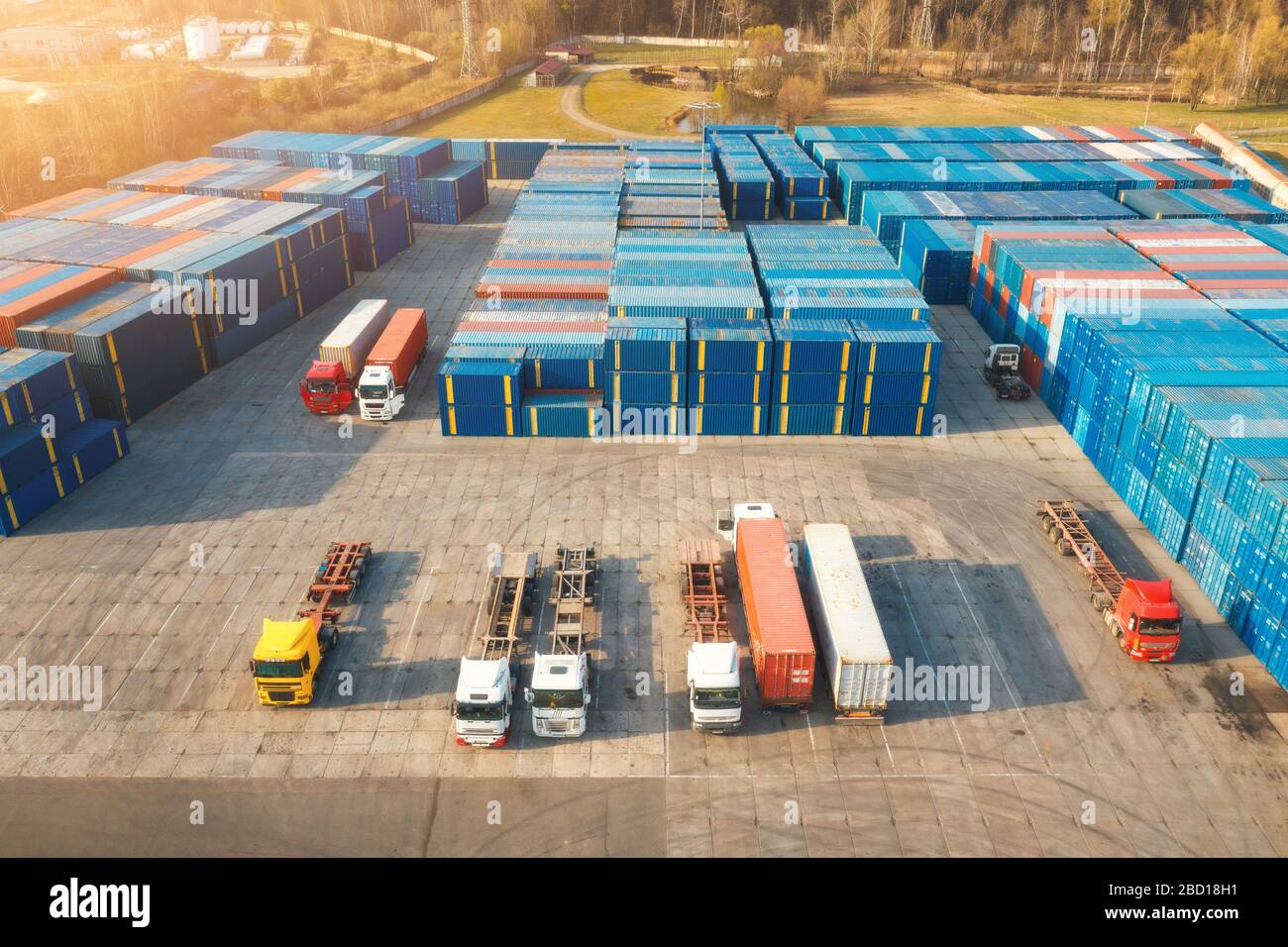 Aerial view of trucks and containers at sunset. Top view Stock Photo