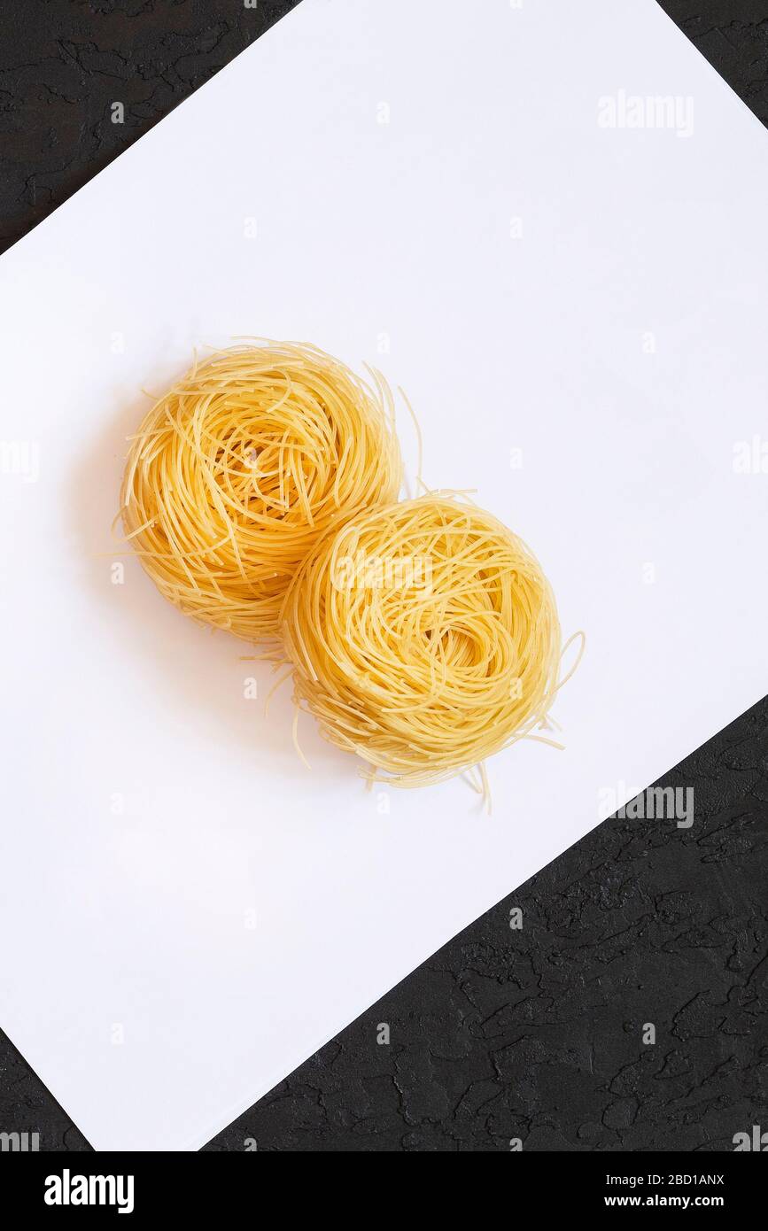 Italian egg pasta tagliatelle nest on black & white background. Capelli
