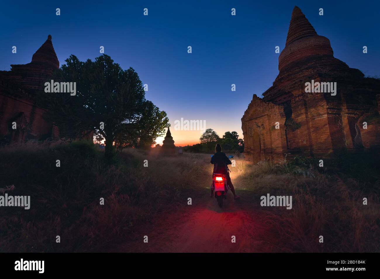 Tourist Visiting Myanmar - Young Woman exploring city of Bagan on electric scooter Stock Photo