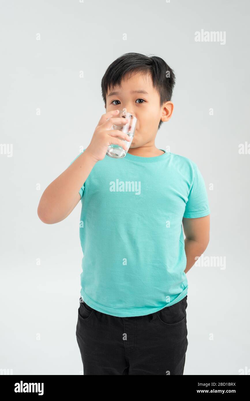 Young little Asian boy taking tablet medicine with a glass of water. Healthcare and Medical concept. Stock Photo