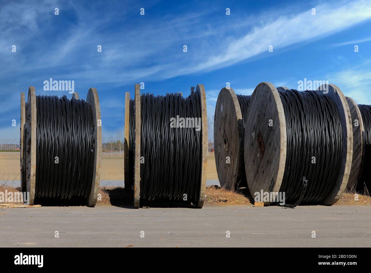 Prysmian Group Wiski Plain cable reels for ground installations at rural work site with blue sky clouds background. Marttila, Finland. April 6, 2019. Stock Photo