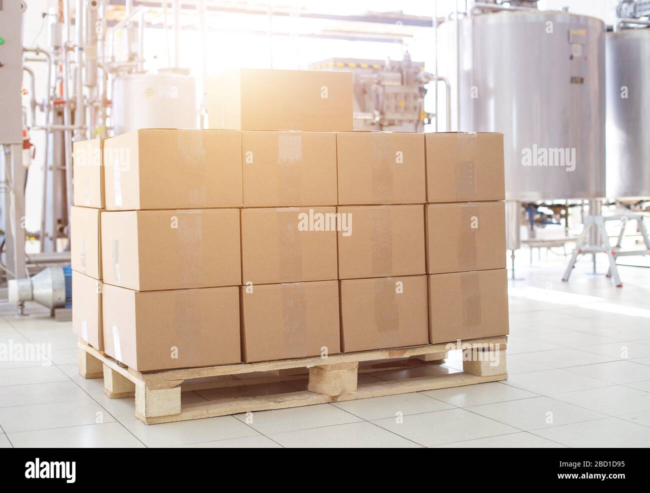 Boxes with finished dairy products at the factory on the background of production equipment. The concept of the production of milk and sour cream, the Stock Photo