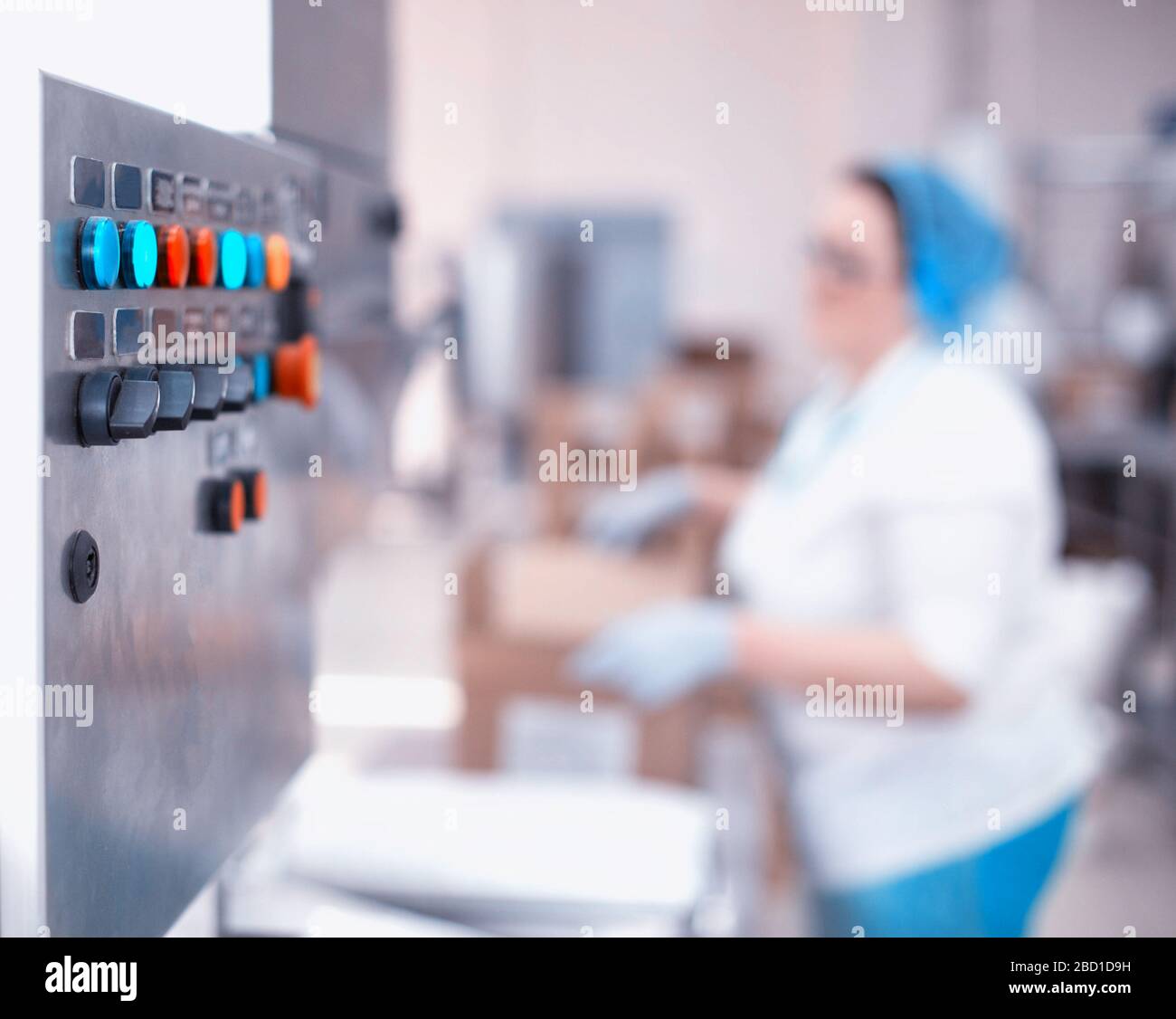 Control panel of an automatic line in production. Woman worker packs products at the factory. Industry, copy space, production line Stock Photo