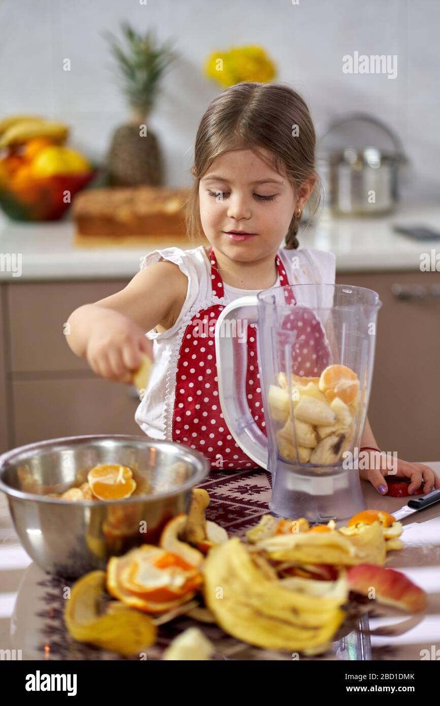 Young girl preparing a smoothie out of many fruits Stock Photo Alamy