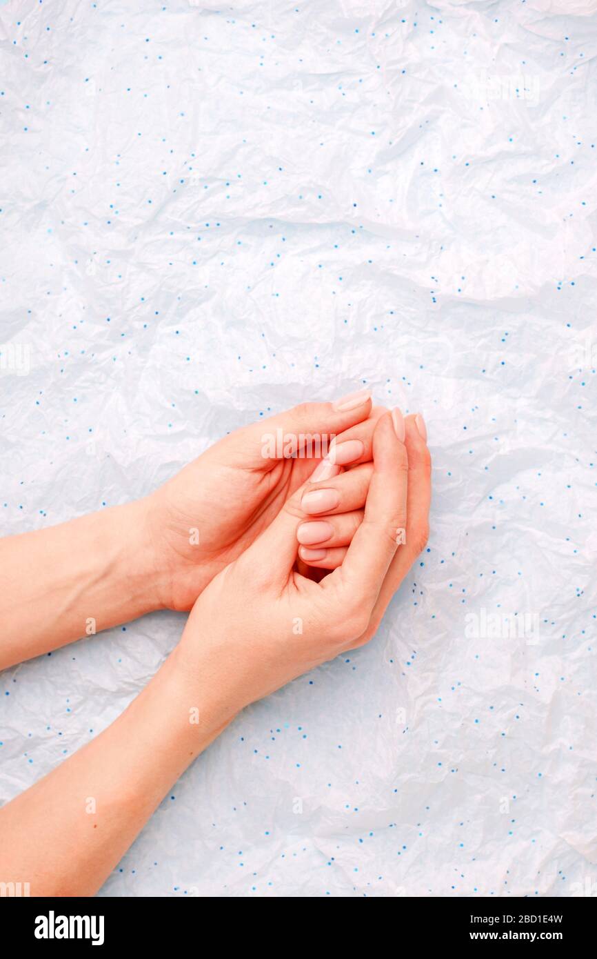 Closeup on woman's hands ith delicate manicure, minimal background, beauty industry spa salon stylish banner, flyer, coupon, copy space Stock Photo