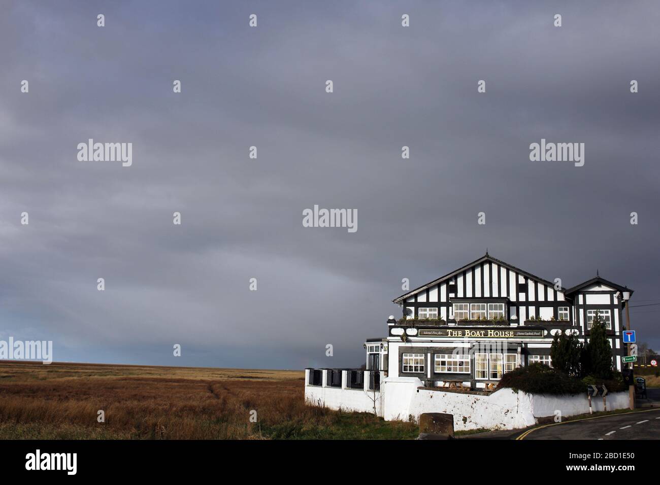 The Boat House Pub amid stormy skies sits on the edge of Parkgate Marsh/Gayton Sands RSPB, Dee Estuary, Parkgate, Wirral, UK Stock Photo