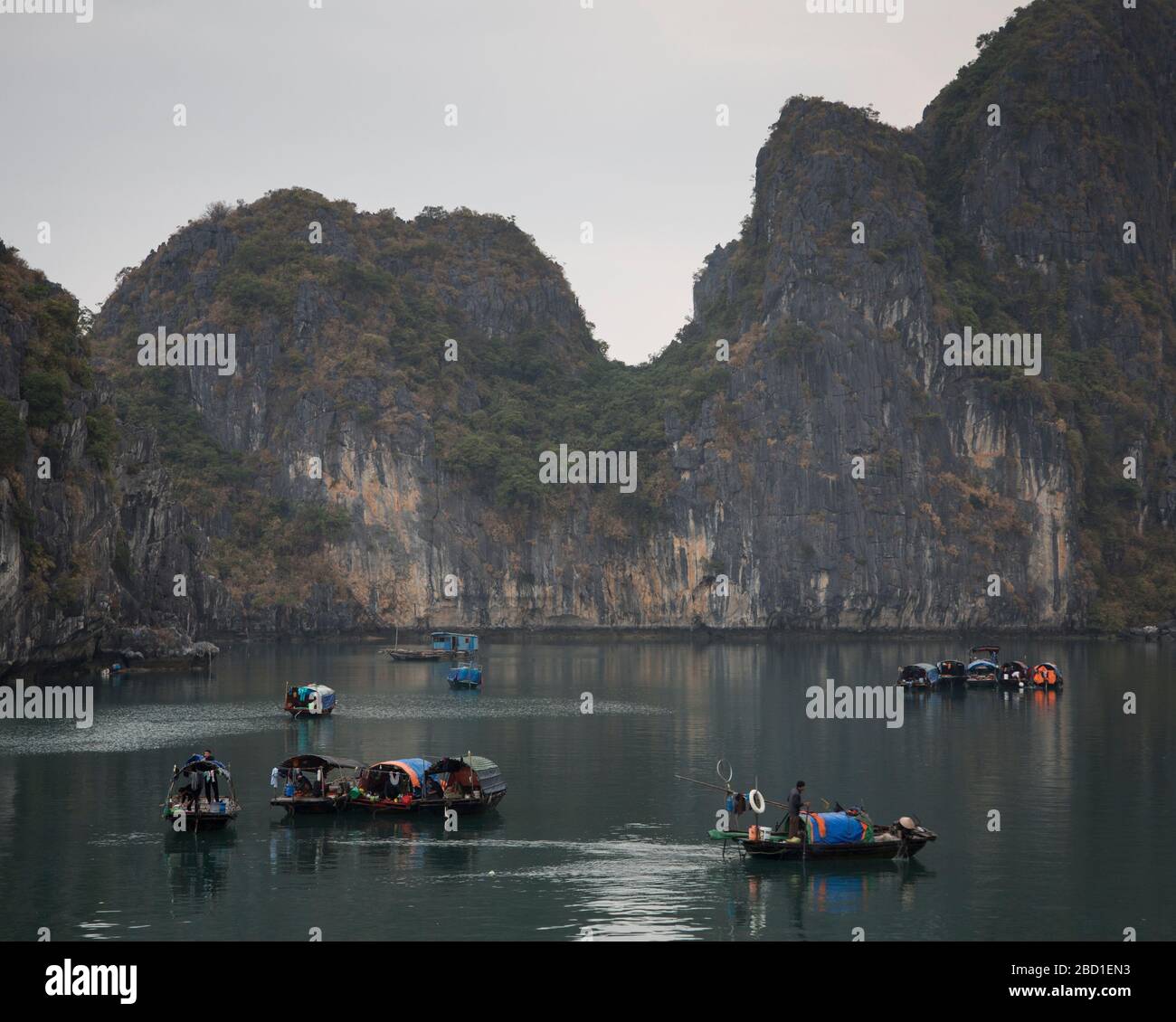 An Early morning view of Ha Long Bay with local fishing boats among the Limestone cliff formations, Stock Photo