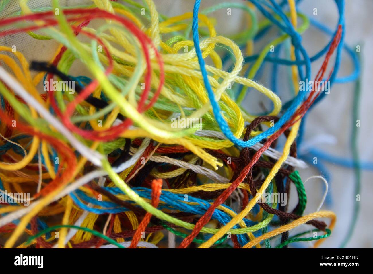 A tangle of multi coloured offcuts of embroidery thread, background texture photo Stock Photo